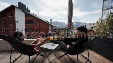阳台上喝果汁，背景上喝雪山。 假期和放松。 可在瑞士阿尔卑斯山欣赏美景。